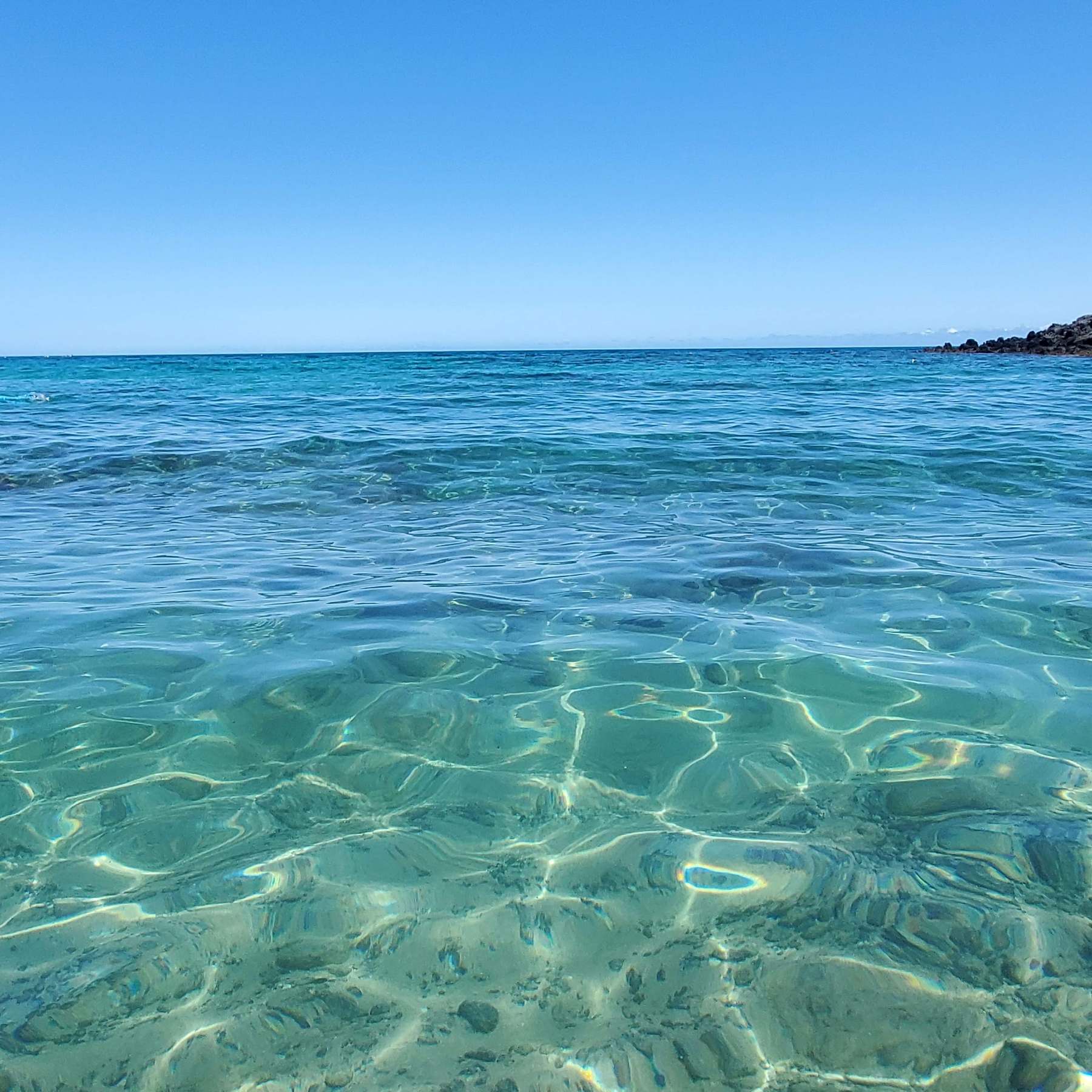 Crystal clear turquoise shallows rippling out to a flat horizon