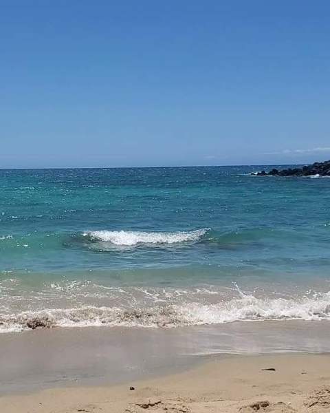 Turquoise waves rolling onto a golden beach